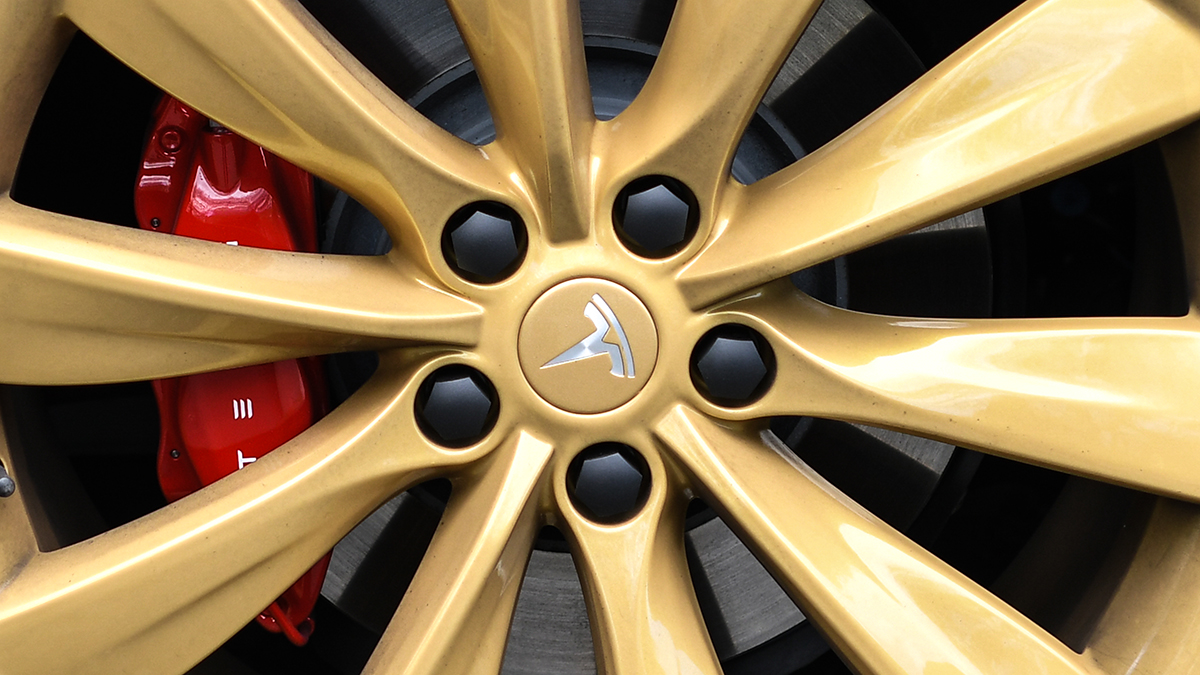 A Tesla logo on the wheel of a Model S car at a launch event.