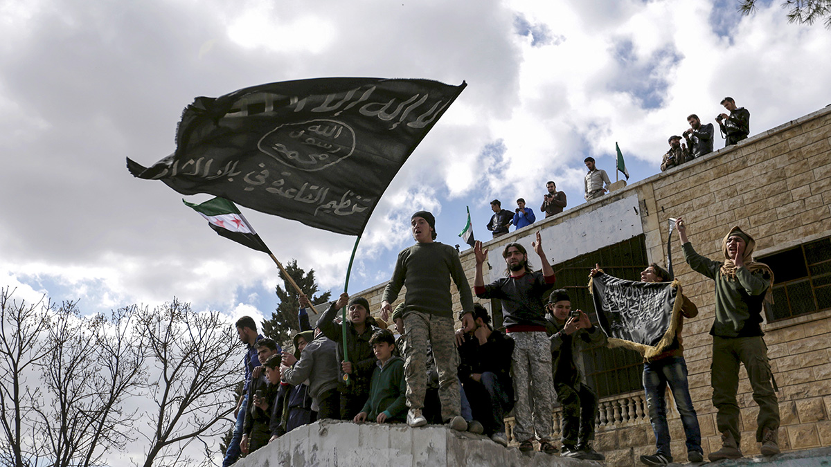 Protesters carry al-Qaeda flags during an anti-government protest in Idlib Governorate, Syria.