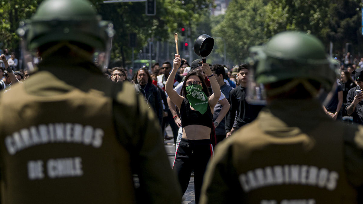 A protester hits a frying pan.