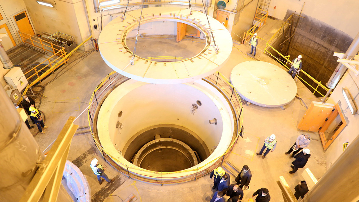 People walk by a water nuclear reactor.
