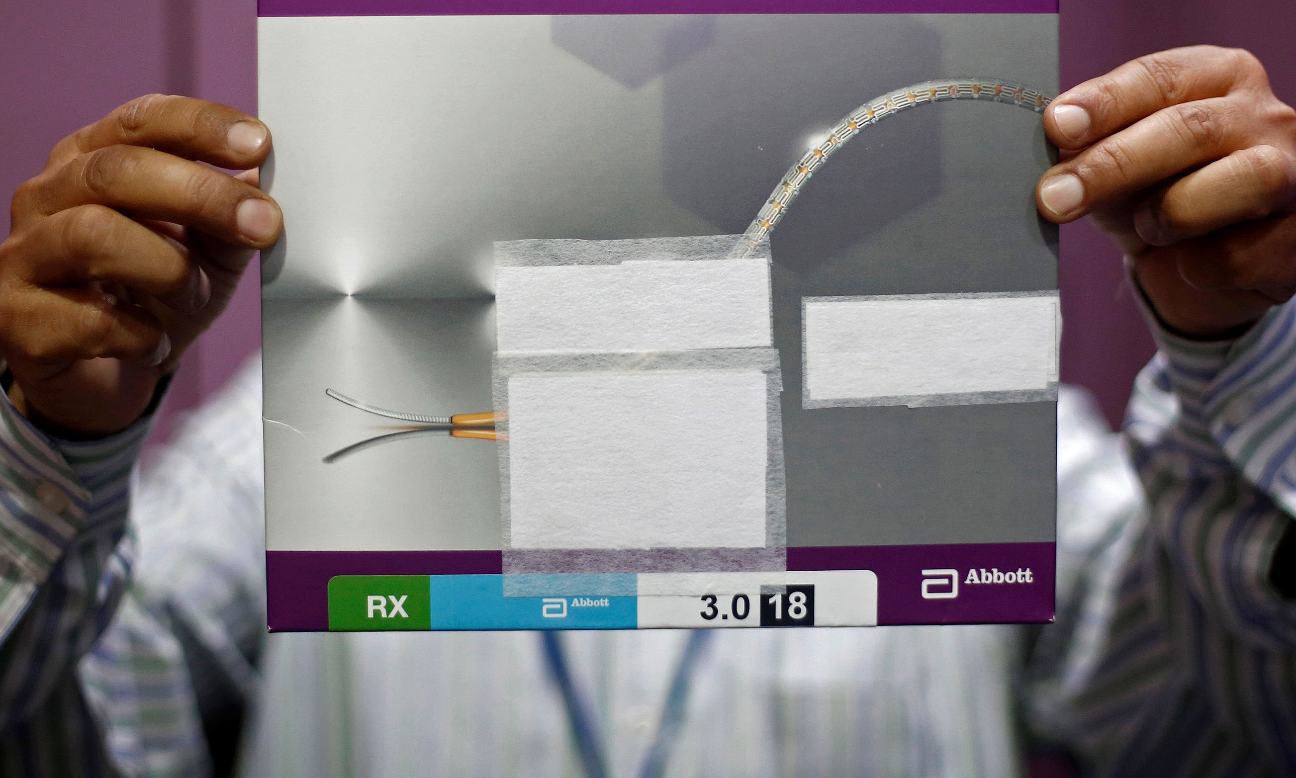 A staff member shows a heart stent inside a store at a New Delhi hospital.