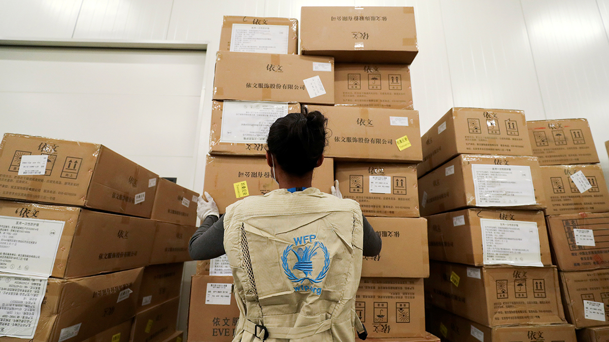 A WFP staff member stacks cardboard boxes of humanitarian aid in an Ethiopian airport.