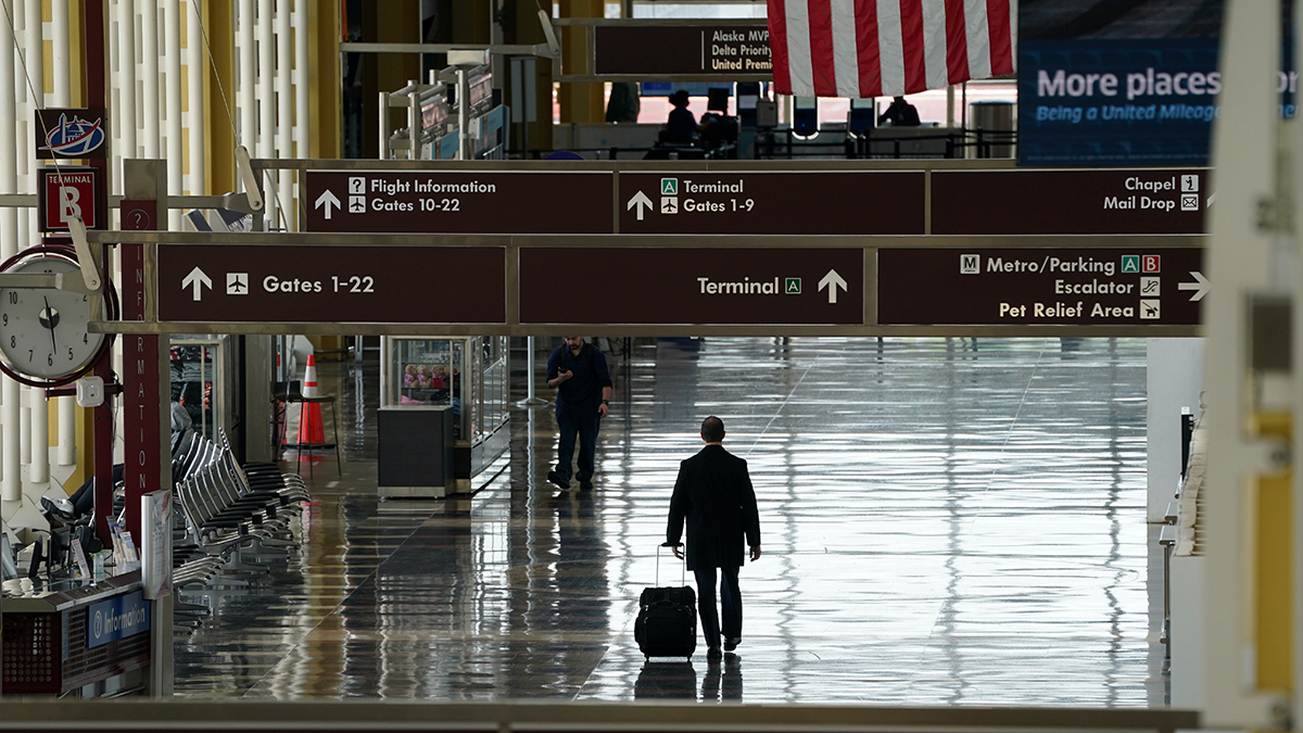 A lone passenger walks through Reagan National airport in Washington, DC, as the novel coronavirus (COVID-19) pandemic continues to keep airline travel at minimal levels.