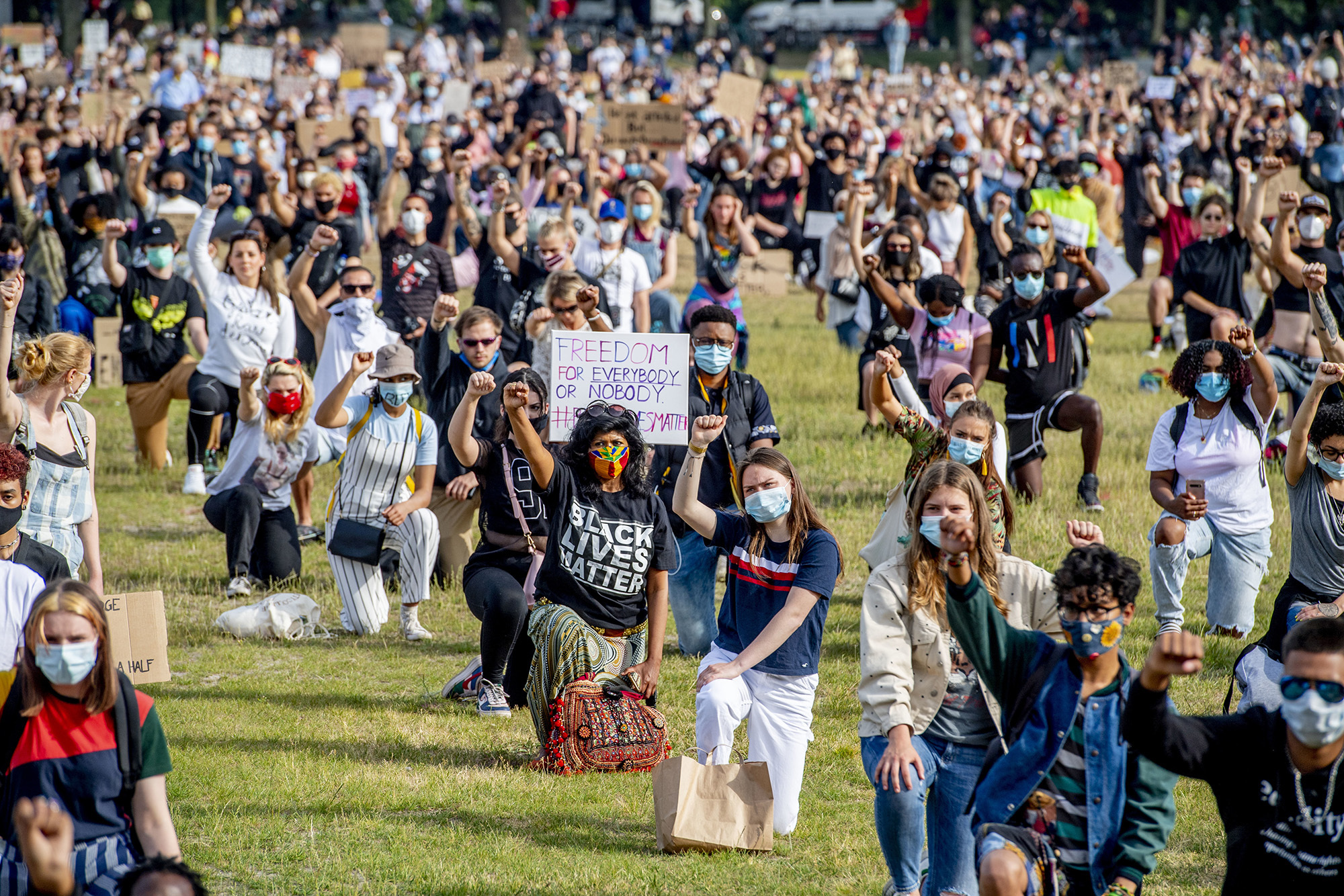 Protesters kneel and raise their fists during a demonstration at Malieveld in The Hague.