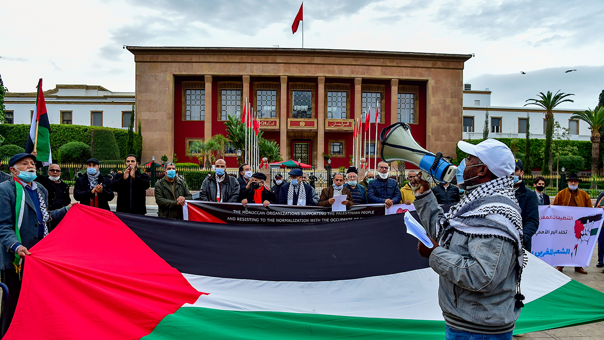Moroccans in Rabat hold a large Palestinian flag in front of Parliament to protest the normalization deal with Israel.