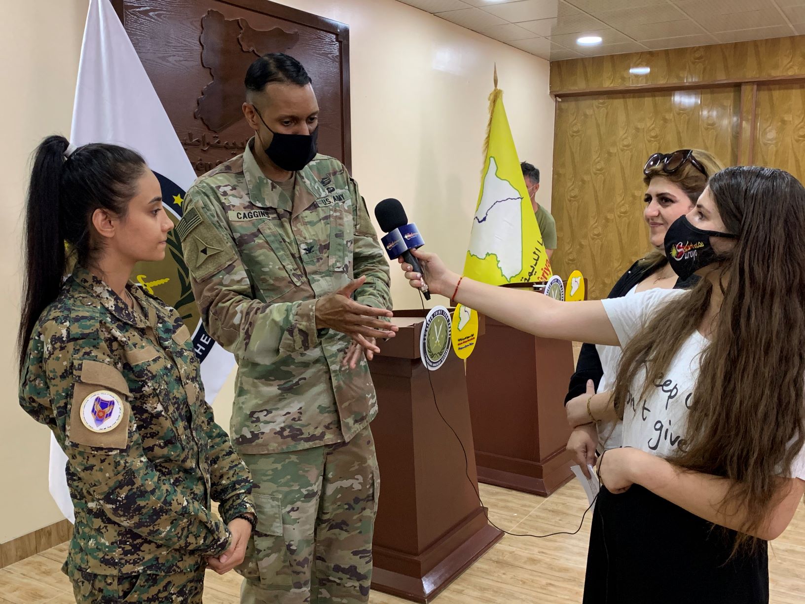  Nisha (left), from the Syriac Christian minority and a member of the Bethnahrin Women’s Protection Units (HSNB), stands next to Colonel Myles Caggins for an interview. This photo was taken by the author. 