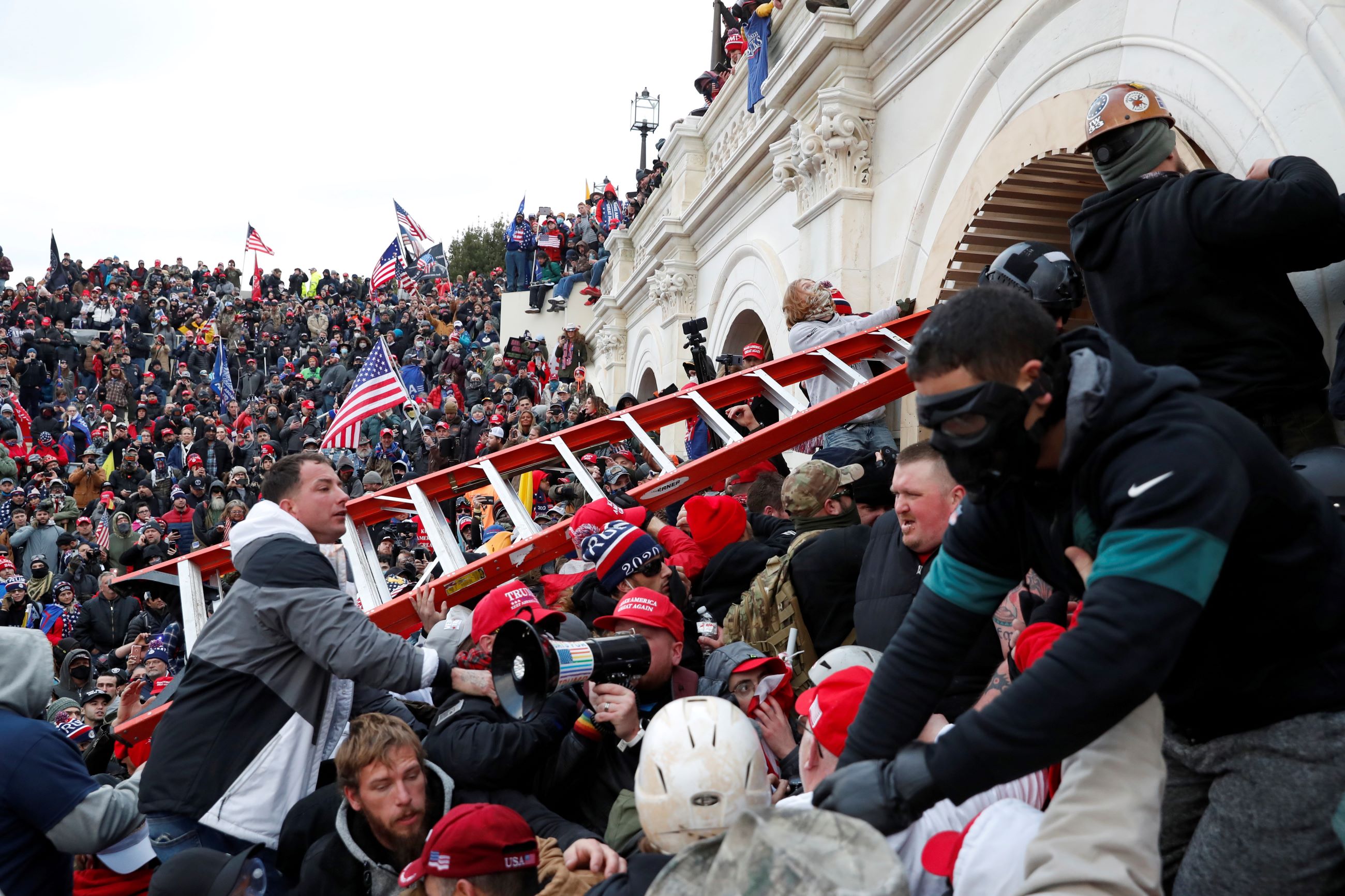 Pro-Trump protesters, holding a ladder, storm the U.S. Capitol on January 6, 2021.