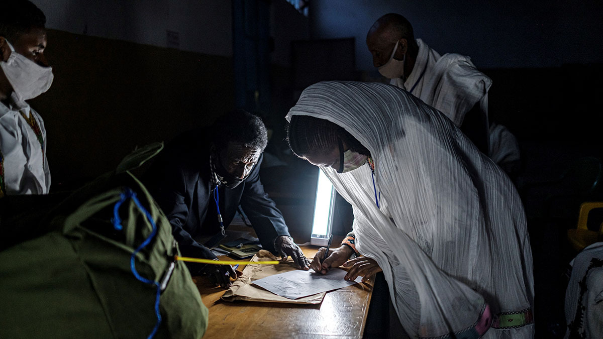 An observer signs a paper marking the closing of the polls in a dark room of a polling station in Mekele during Tigray’s regional elections in September 2020.
