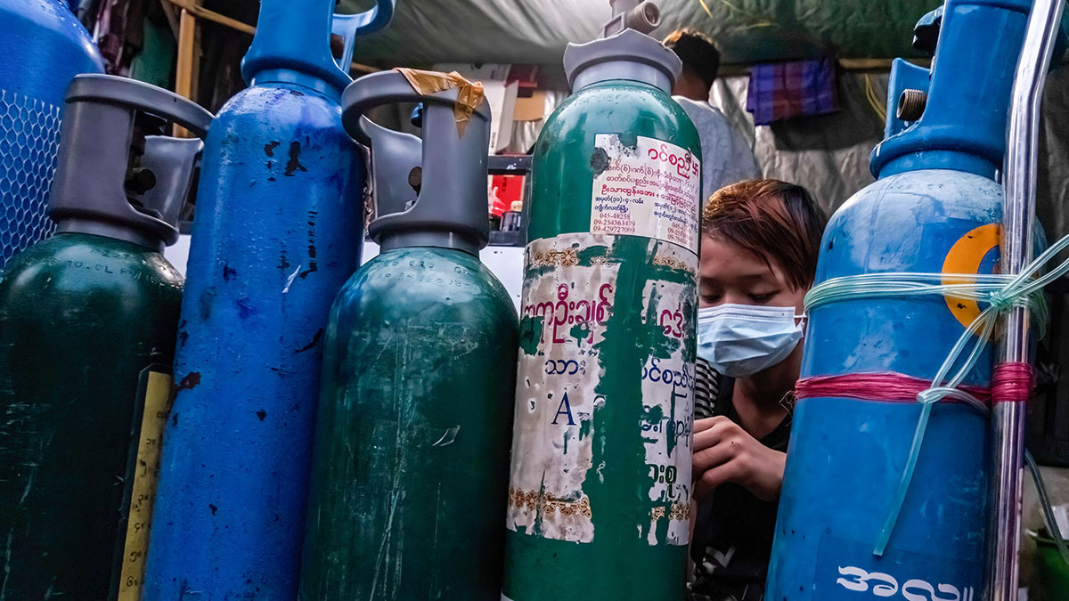 A person is surrounded by oxygen tanks in a small room. 