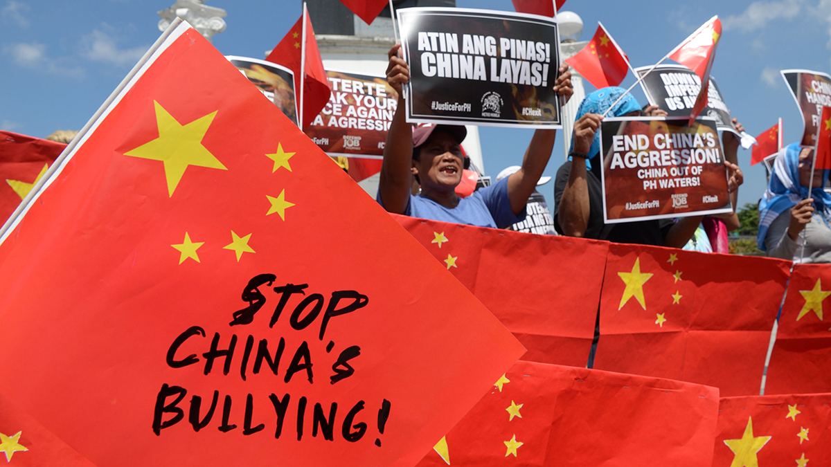 People hold signs during a protest saying 