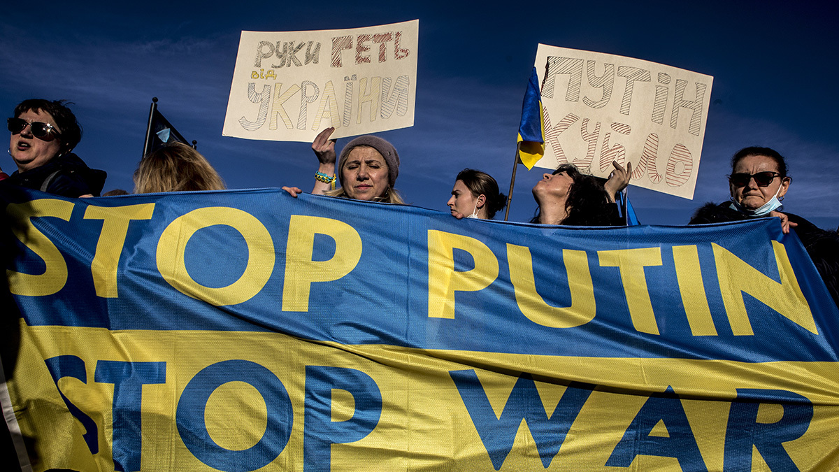Protesters from the Christian Ukrainian Community of Rome hold signs, including one that reads, 