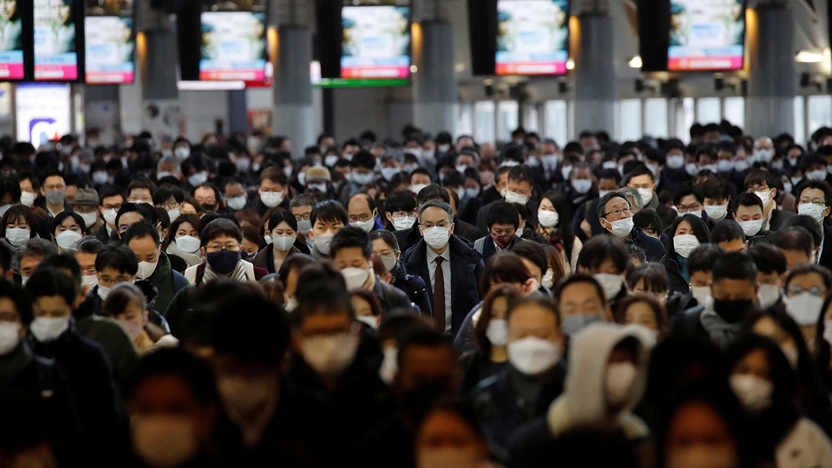People wear masks at a train station in Japan.