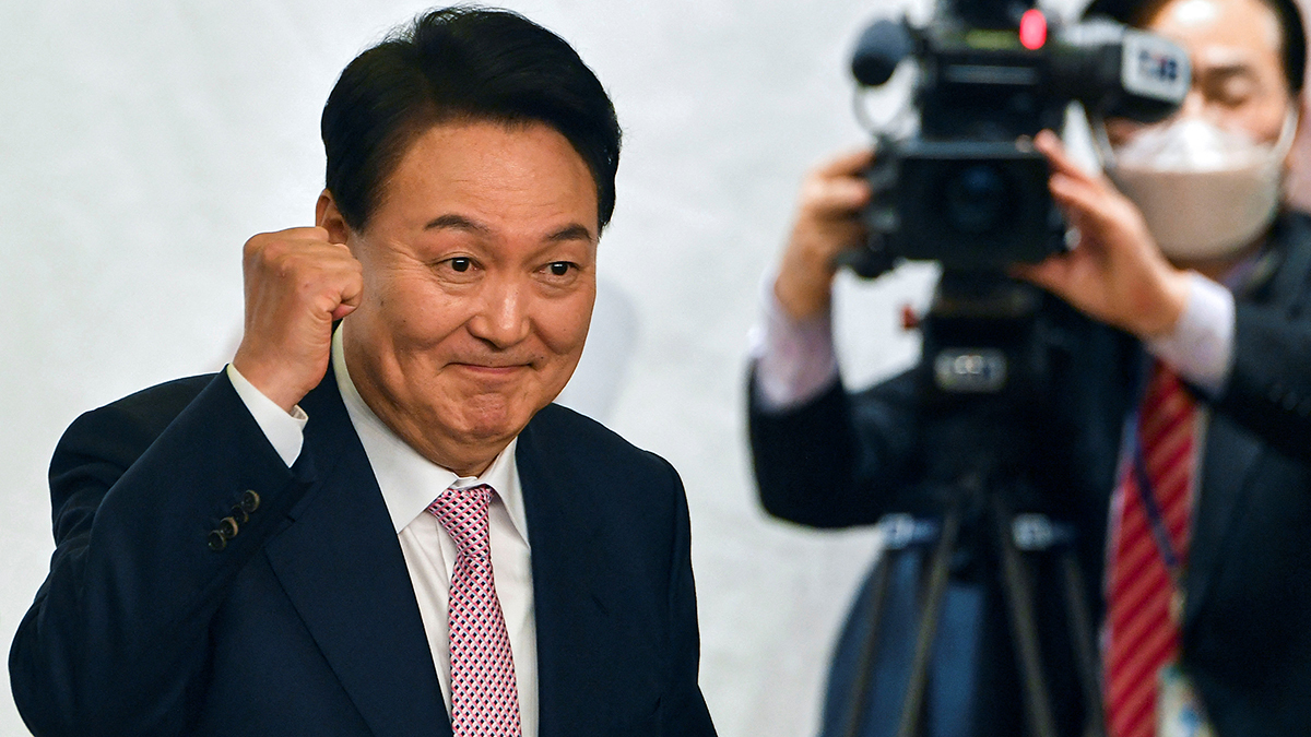 President-Elect Yoon pumps his fist and smiles. 