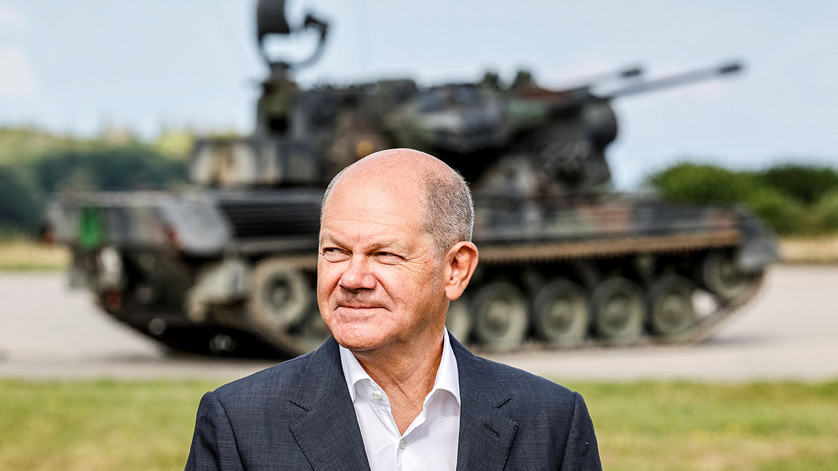 German Chancellor Olaf Scholz stands in front of an anti-aircraft gun in Putlos. 