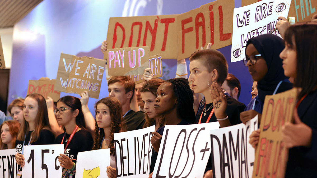 Young people hold signs calling for climate action. 