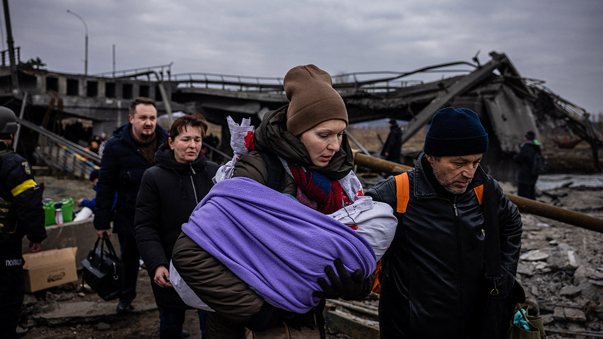 A group of refugees crosses a destroyed bridge as they flee the city of Irpin, Ukraine, amid Russia’s invasion.