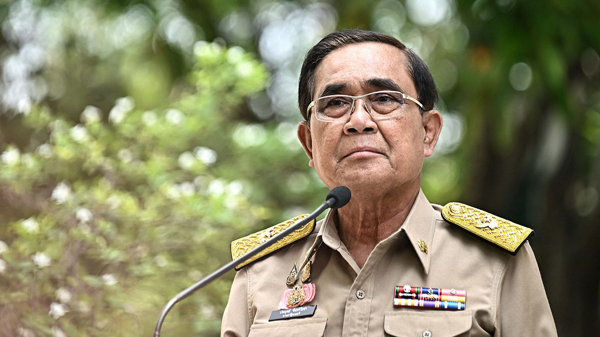 Thailand's prime minister, dressed, in military uniform, speaks into a microphone.