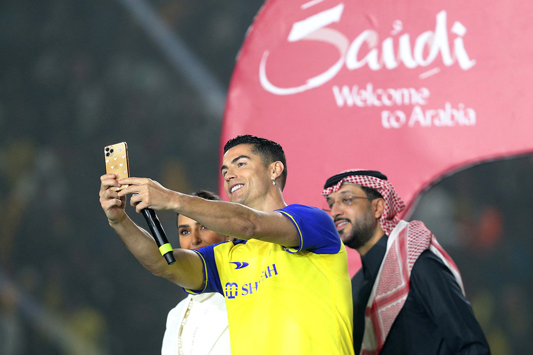 Cristiano Ronaldo extends his phone to take a selfie upon arrival in Saudi Arabia.