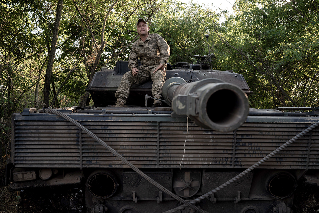 A Ukrainian soldier sits on a German-made Leopard tank.