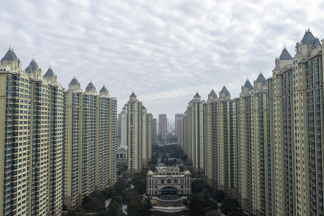 Rows of identical residential skyscrapers mirror each other across a park.
