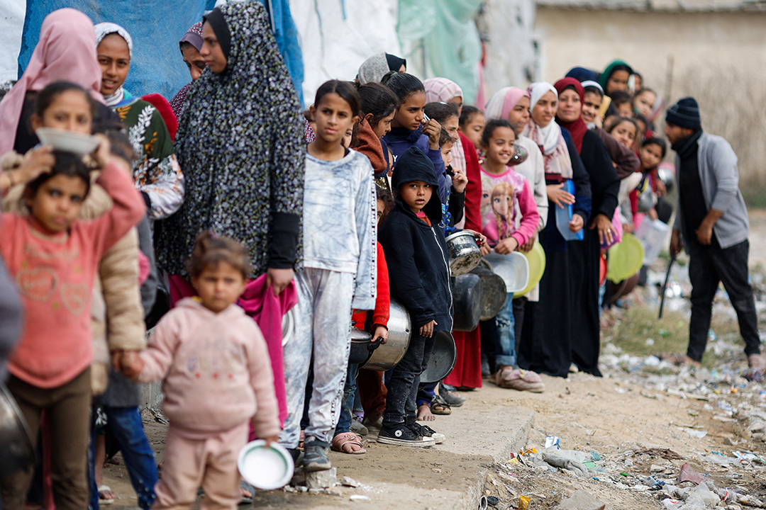 Palestinians wait in line to receive food in Rafah in the southern Gaza Strip.