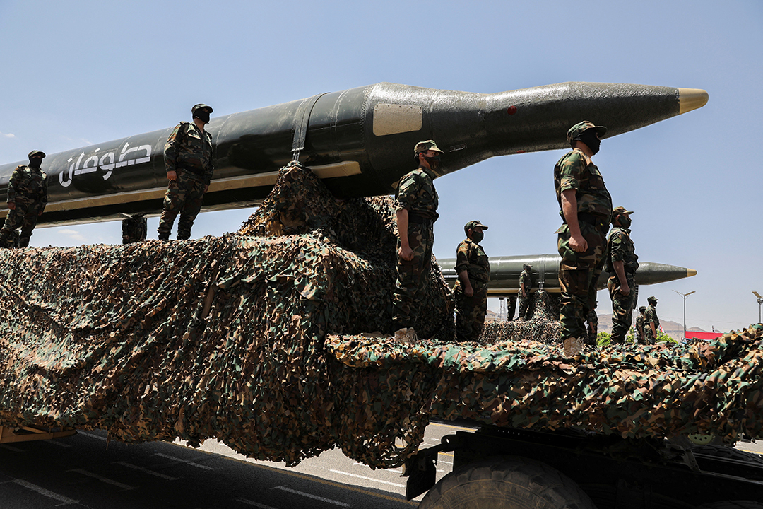 Houthi fighters display ballistic missiles during a military parade