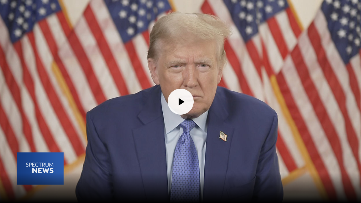 Trump as viewed in front of a row of American flags.
