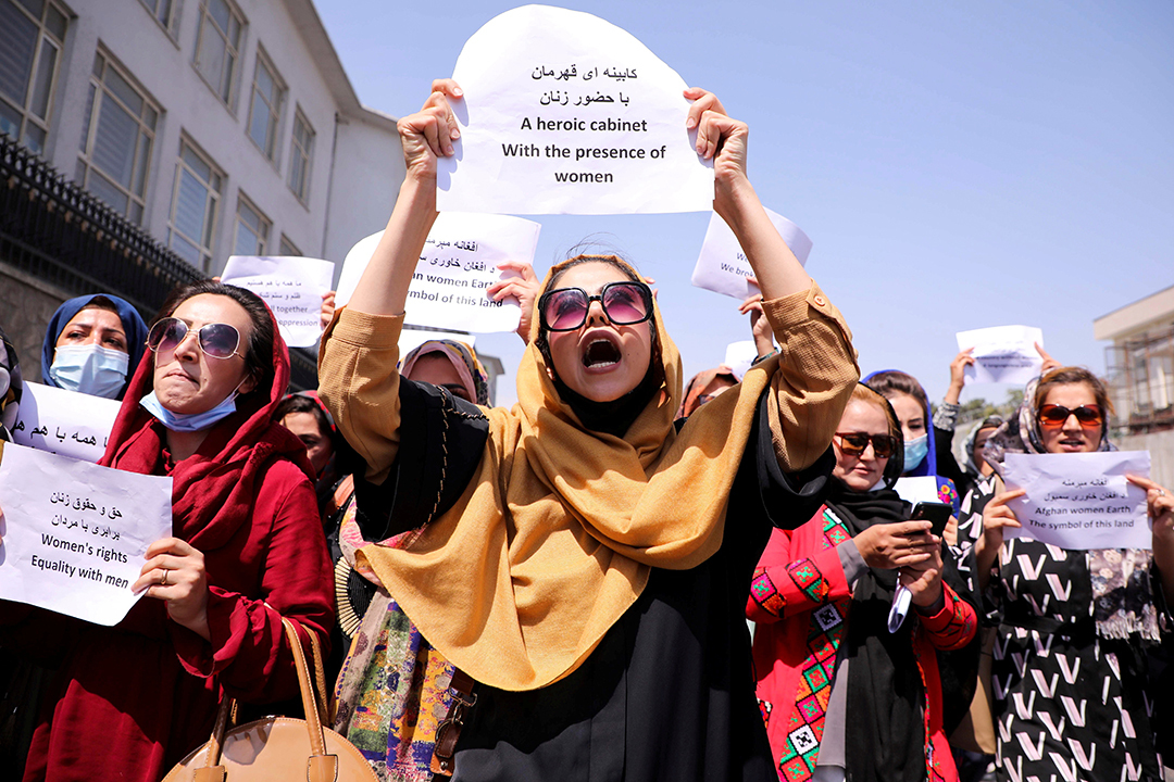 Women protestors hold up signs.