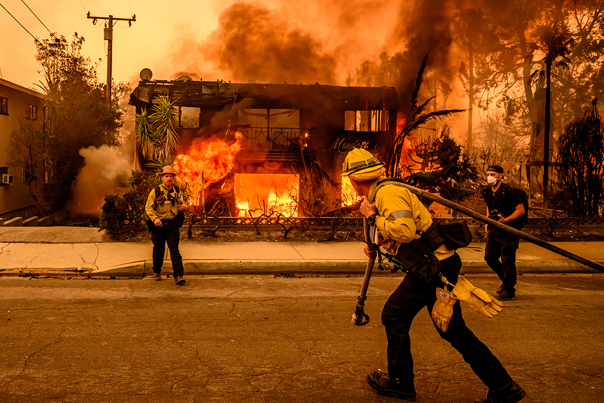 Firefighters work the scene as an apartment building burns during the Eaton fire in the Altadena area of Los Angeles county, California on January 8, 2025.