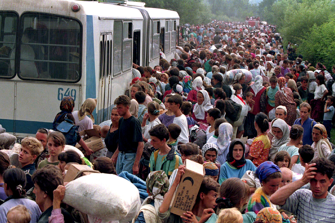 Refugees from Srebrenica board buses at a camp outside the UN base at Tuzla airport, July 14, 1995.